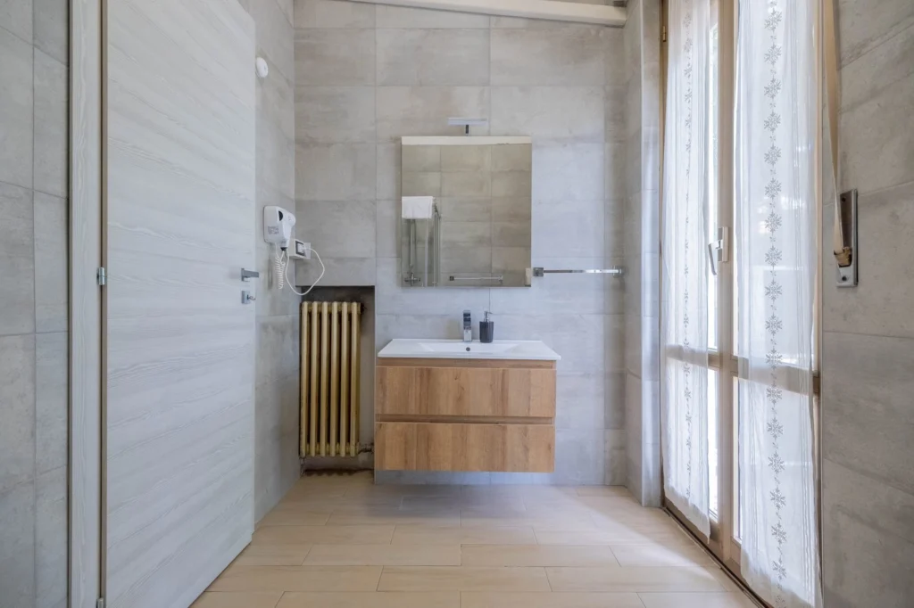 Bagno della camera doppia con lavabo, specchio e asciugacapelli